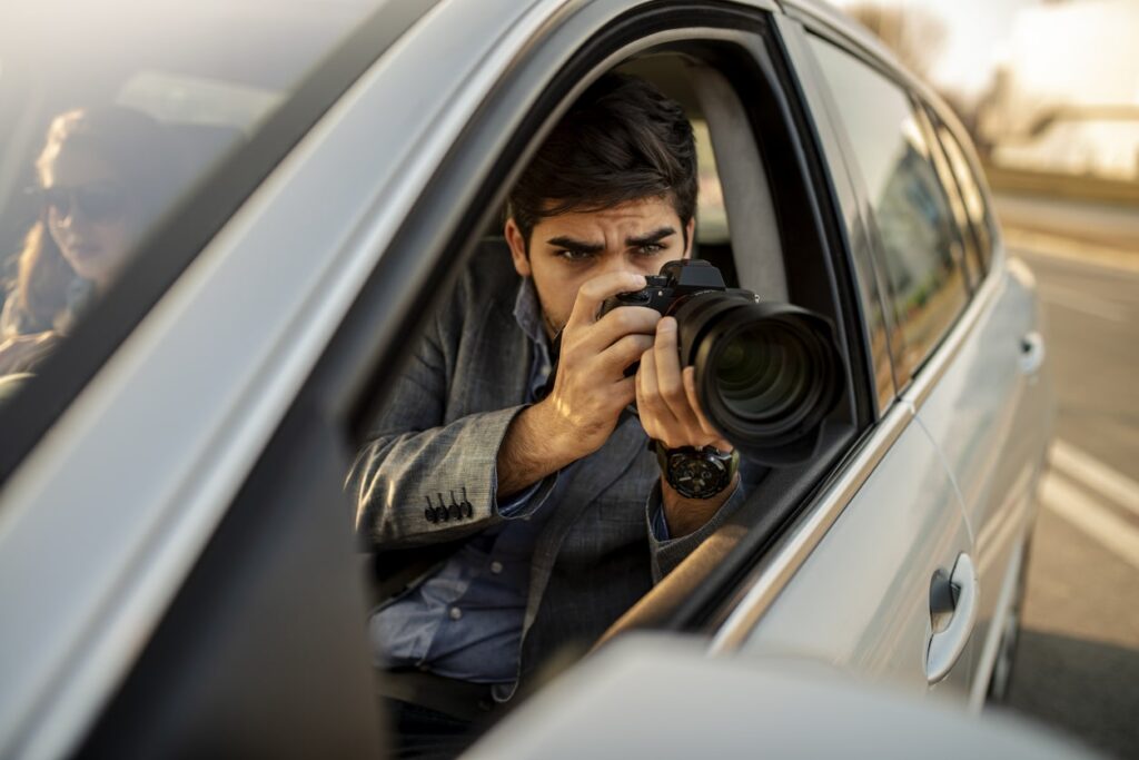 private detective performing surveillance from car