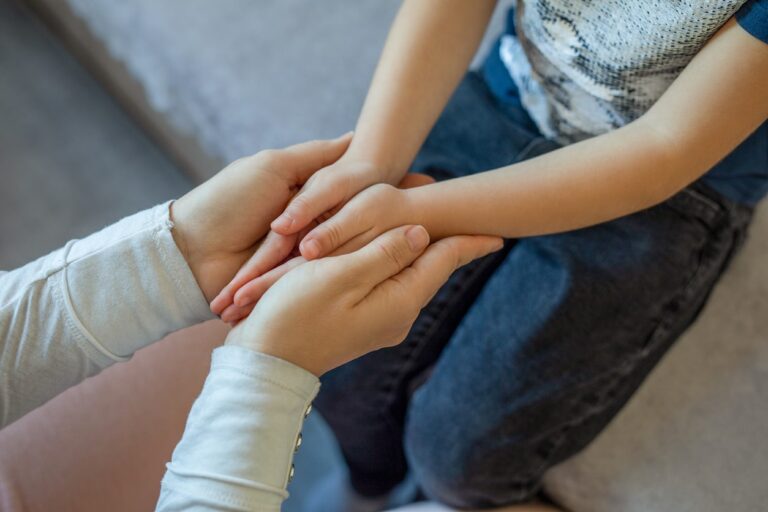 parent holding childs hand during custody battle